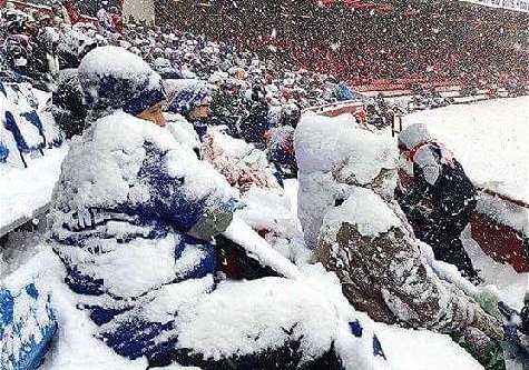Fans covered in snow at a football match